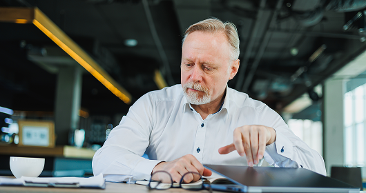 Business owner reviewing notes at a laptop in a loft office