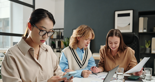 In-house accounting team reviewing documents and a laptop at a shared desk